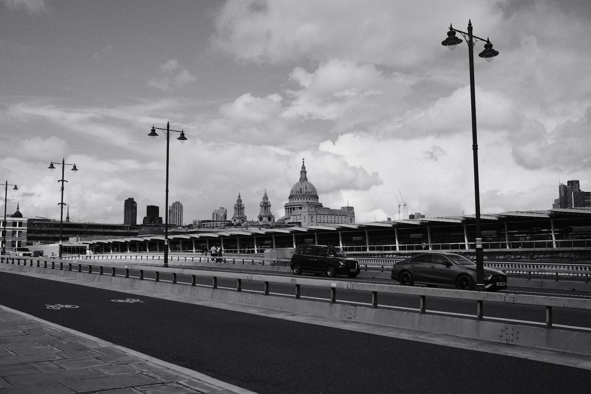 grayscale Blackfriars Bridge in London with vehicles passing